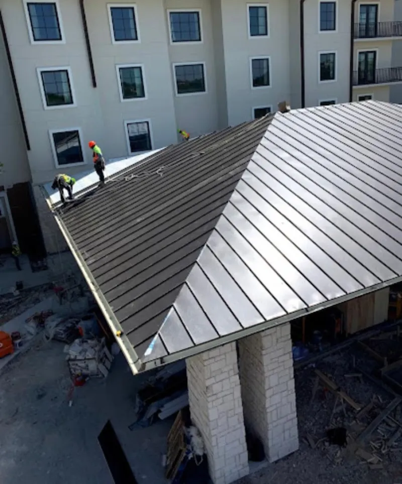 Crew installing standing seam metal roof panels on a commercial project in University Place